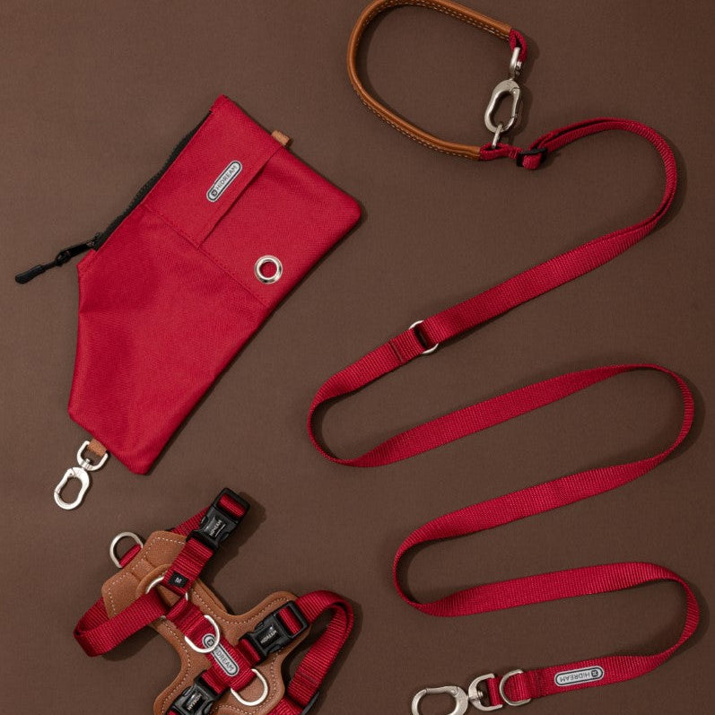 Red dog leash and harness set on a brown background