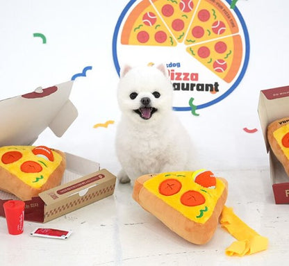 White dog with pizza-themed plush toys and a toy restaurant set on a white background