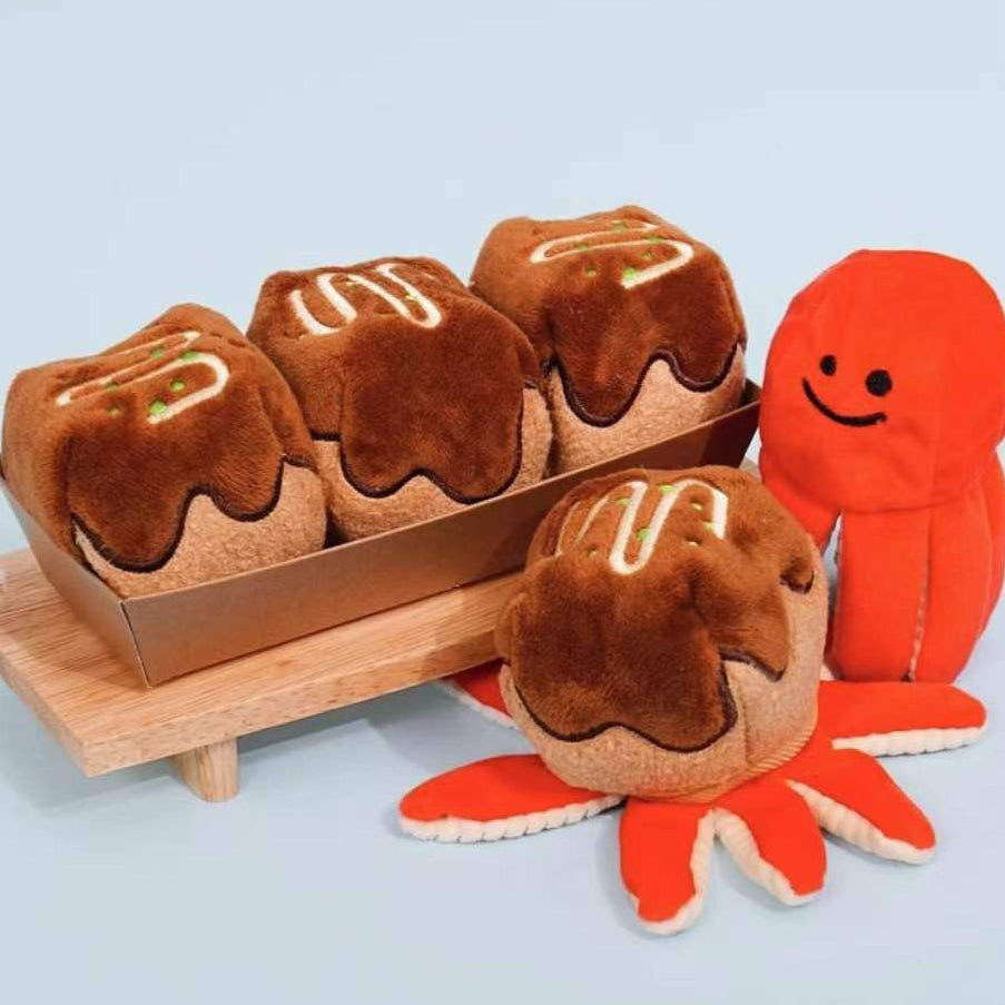 Plush toy resembling a lobster with a smiling face on a light blue background
